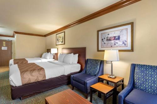 奥罗拉丹佛机场休闲公园品质套房酒店的酒店客房,配有一张床和两把椅子