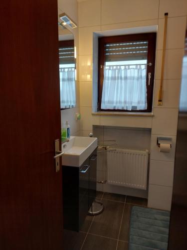 巴特武尔察赫FeWo1&Dreibettzimmer的一间带白色水槽和窗户的浴室