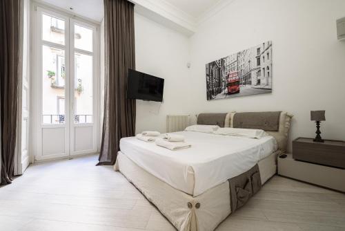 那不勒斯Palazzo dello Spagnolo Suite的白色的卧室设有一张大床和一个窗户