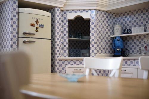 那不勒斯Palazzo dello Spagnolo Suite的厨房配有桌子和冰箱