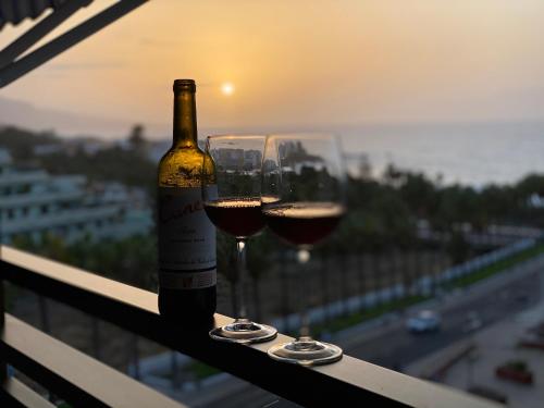 拉克鲁斯LOFT vistas playa jardin的阳台上的一瓶葡萄酒和两杯酒