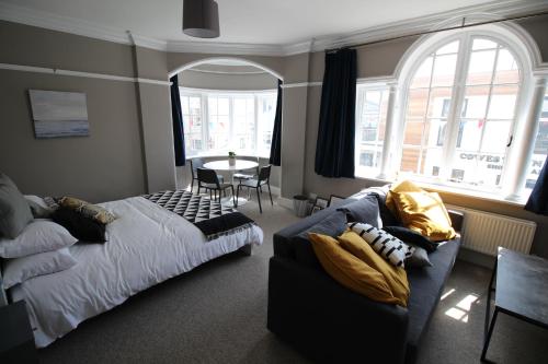 考斯Pier View Studio Apartment的一间卧室配有一张床、一张沙发和一张桌子