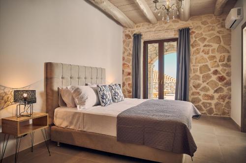 MaryiésIoanna Château - Luxury Stone Villa的一间卧室设有一张床和石墙