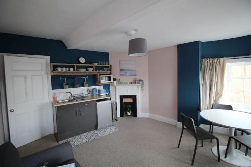 考斯Pier View 2 Bedroom Apartment的厨房拥有蓝色的墙壁,配有桌椅
