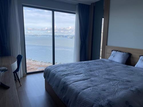 下龙湾Citadine Ha Long luxury (Ocean View)的一间卧室设有一张大床和一个大窗户