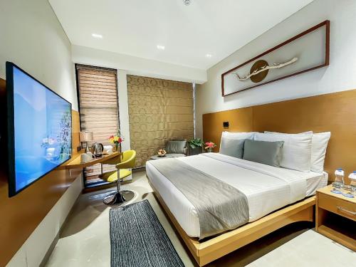 加尔各答Morvee Hotels Alipore Kolkata的一间卧室配有一张床和一台平面电视