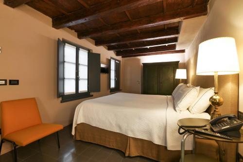 米兰伯瑞拉梅森酒店的一间卧室配有一张床、一张桌子和一部电话