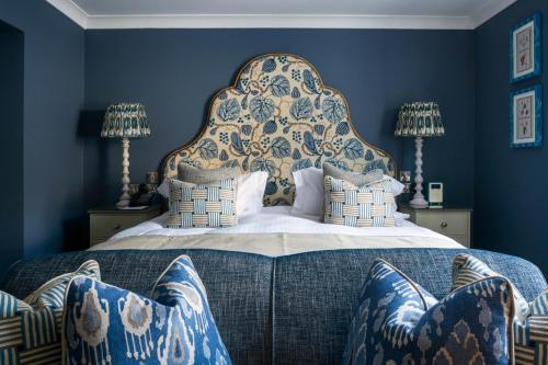 纽基赫兰酒店和Spa的一间卧室配有一张带蓝色墙壁的大床