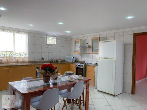 圣特雷莎Spazio Martinelli的厨房配有桌子和白色冰箱。