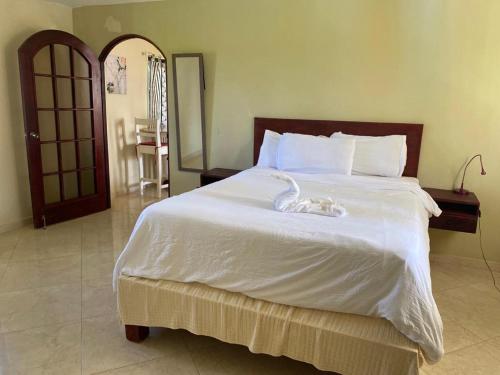 喀巴里特El Cabarete Spa Resort all-Inclusive的卧室配有一张白色大床和天鹅