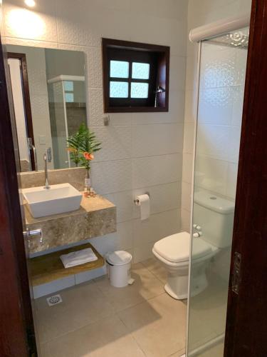 瓜拉米兰加Pousada Chale Cana Brava的一间带卫生间、水槽和镜子的浴室