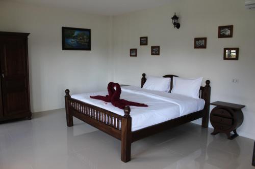 蔻立Villa Colina Khao Lak Rooms and Bungalows - Adults Only的一间卧室配有一张红色带子的床