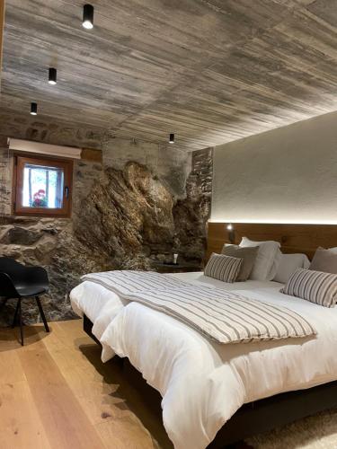 莱塞斯卡尔德-恩戈尔达Era del Rafel的一间卧室设有一张带石墙的大床