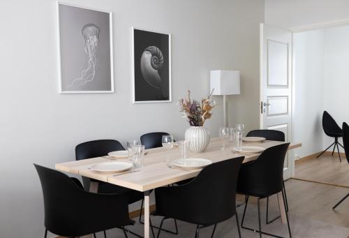 赫尔辛基2ndhomes Bright 1BR Apartment with Superb Location!的一间带桌子和黑色椅子的用餐室