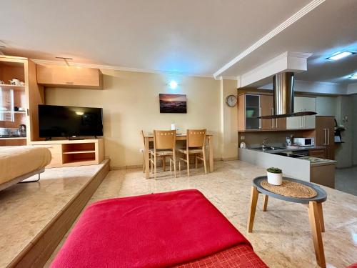 阿里纳加Las Nasas, Acogedor apartamento cerca de la playa的客厅配有沙发和一张红色地毯的桌子