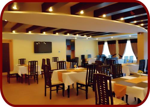 伊斯兰堡帕拉佐酒店的用餐室配有桌椅和平面电视。
