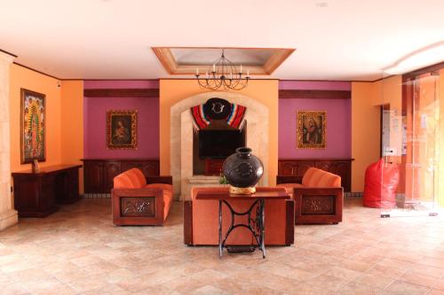 瓦哈卡市圣埃伦娜广场酒店的客厅拥有橙色和紫色的墙壁