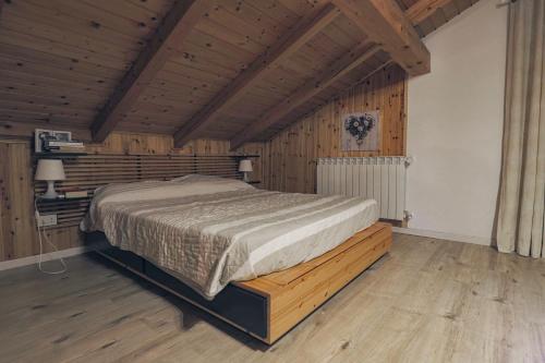 阿莱盖Una Civetta sul Lago的木制客房内的一间卧室,配有一张床