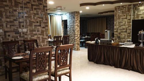 Mawāliḩ马斯喀特地平线酒店的餐厅设有桌椅和砖墙