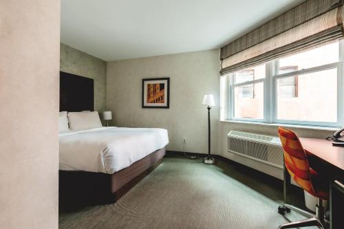 纽约Solita Soho Hotel的一间卧室配有一张床、一张书桌和一个窗户。