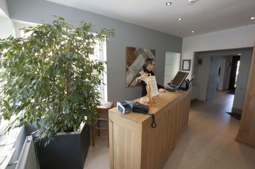 CorbaisHotel Piano 2 - Mont-St-Guibert - Louvain-la-Neuve的坐在办公室桌子上的男人