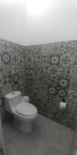 圣玛丽戴尔奥罗Hotel Lucero Chan的浴室设有卫生间,墙上铺有瓷砖。