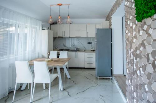 蒂米什瓦拉Casa Habitat的厨房配有木桌和白色椅子