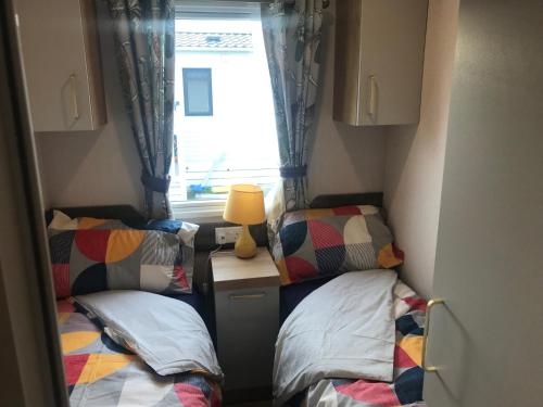 Kirby MispertonFlamingo Land Private Caravan - No 8 Cedarwood的小房间设有两张床和窗户