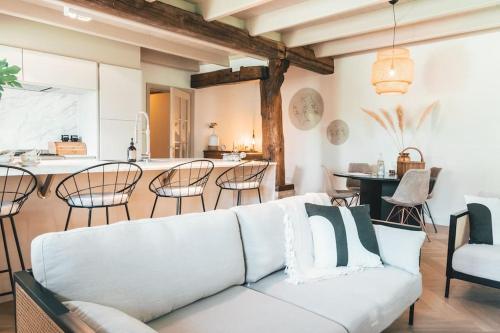 TwiskMonumentale stolpboerderij voorzien van alle gemakken van nu!的一间带白色沙发的客厅和一间厨房