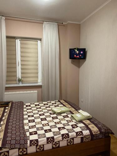 利沃夫Відпочинковий комплекс,міні готель Старий дворик的卧室配有一张床铺,墙上配有电视