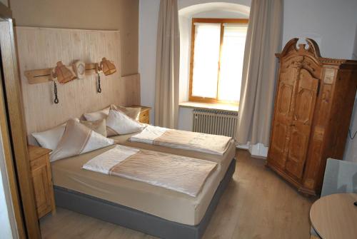 纳堡Gasthof Schwarzer Adler的一间小卧室,配有两张床和窗户