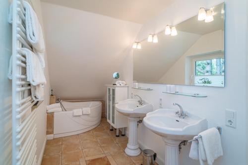 曼克玛肖Söns Hüs的浴室设有2个水槽、浴缸和镜子