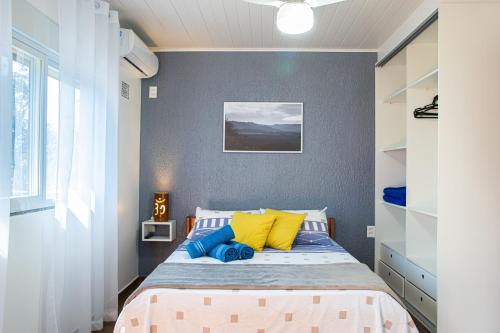 加罗帕巴Residencial Paraíso da Gamboa的一间卧室配有黄色和蓝色枕头的床