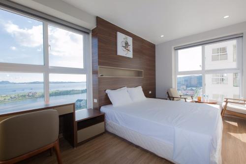 下龙湾Chuỗi căn hộ Minh Phúc homestay Hạ Long的卧室设有白色的床和大窗户