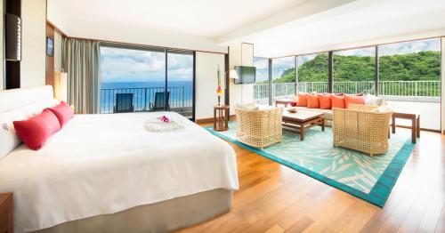 塔穆宁关岛日航酒店的一间带大床的卧室和一间客厅