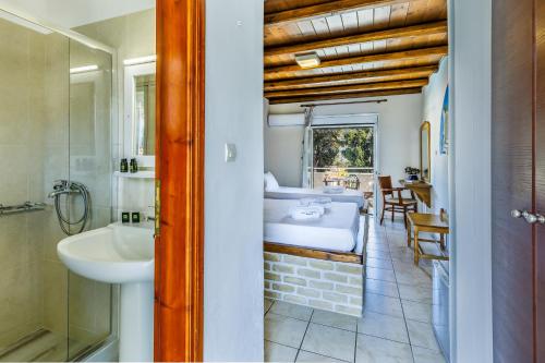 斯科派洛斯Ionia Hotel的一间带水槽的浴室和一张位于客房内的床