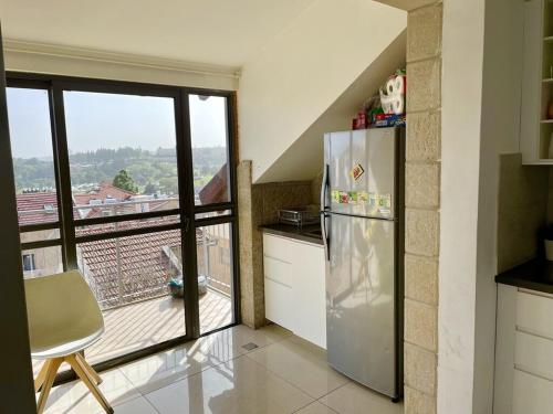 耶路撒冷Gorgeous duplex in heart of Jerusalem的一间带不锈钢冰箱的厨房和一个阳台
