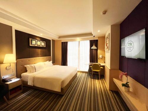 曼谷曼谷市集酒店的酒店客房,配有床和电视