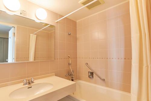 一关KAMENOI HOTEL Ichinoseki的一间带水槽、浴缸和镜子的浴室