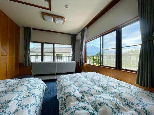 富士河口湖富士旅の家的一间卧室设有一张床和一个大窗户
