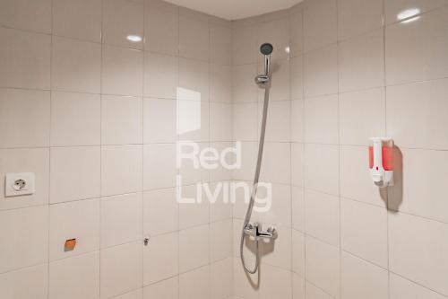 万隆RedLiving Apartemen Mekarwangi Square - M Express的浴室设有淋浴,墙上有红色的活标志