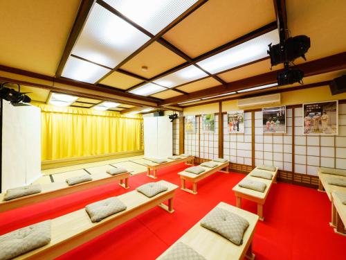 嬉野市Ureshino Onsen Kotobukiya的一间设有一排长椅和桌子的房间