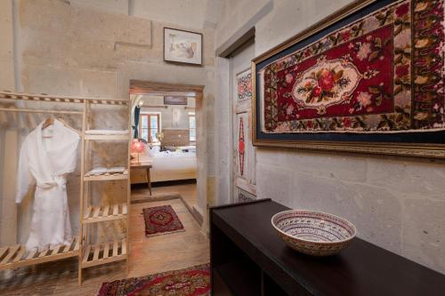 阿瓦诺斯HacıAşık Konağı Butik Hotel的一间设有地毯和桌子的墙壁的房间