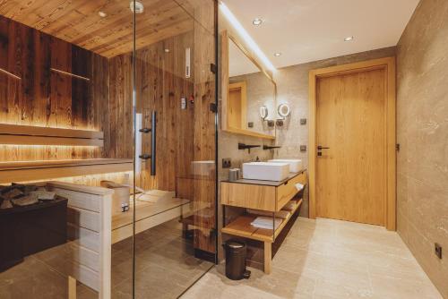卡普伦Bergdorf Hotel Zaglgut的一间带玻璃淋浴和水槽的浴室