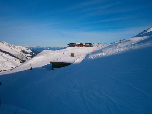 菲根贝格Panorama Lodge Hochfügen的一座白雪覆盖的山,上面有一座建筑
