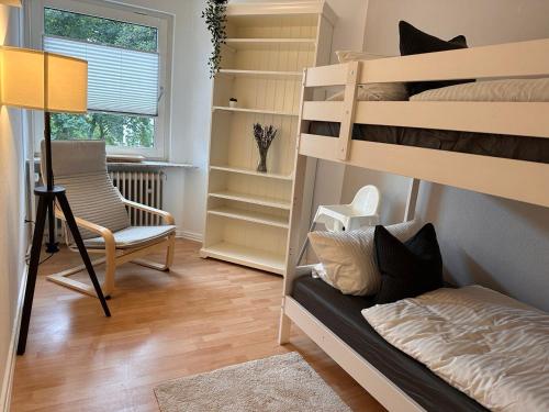 伍珀塔尔Wohnung in Wuppertal Elberfeld的带两张双层床和椅子的房间