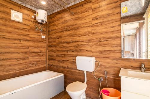斋沙默尔Bhati Desert Camp Sam的一间带木墙、浴缸和卫生间的浴室