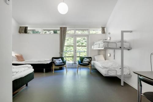 希勒勒希勒勒大宿舍酒店的带两张双层床和两把椅子的房间