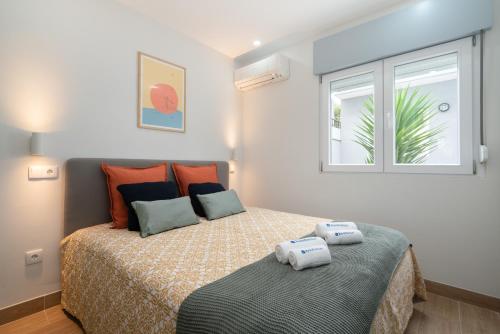 波尔图Charming Bright House w/ Garden的一间卧室配有一张床,上面有两条毛巾
