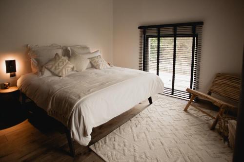 那慕尔Comme chez Lore - villa 2pers - piscine chauffée的卧室设有一张白色大床和一扇窗户。